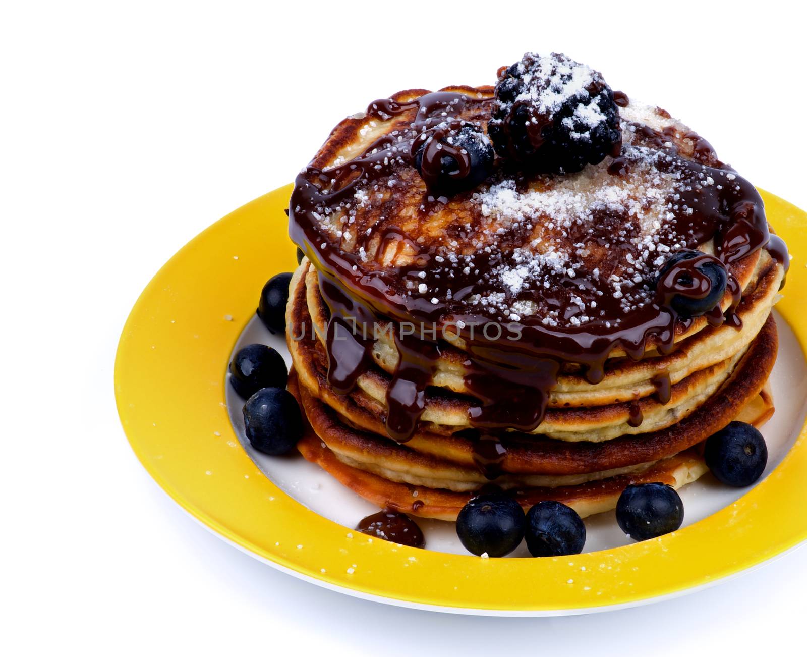 Stack of Delicious Pancakes with Various Forest Berries, Chocolate Glaze and Sugar Powder on Yellow Plate Cross Section on White background
