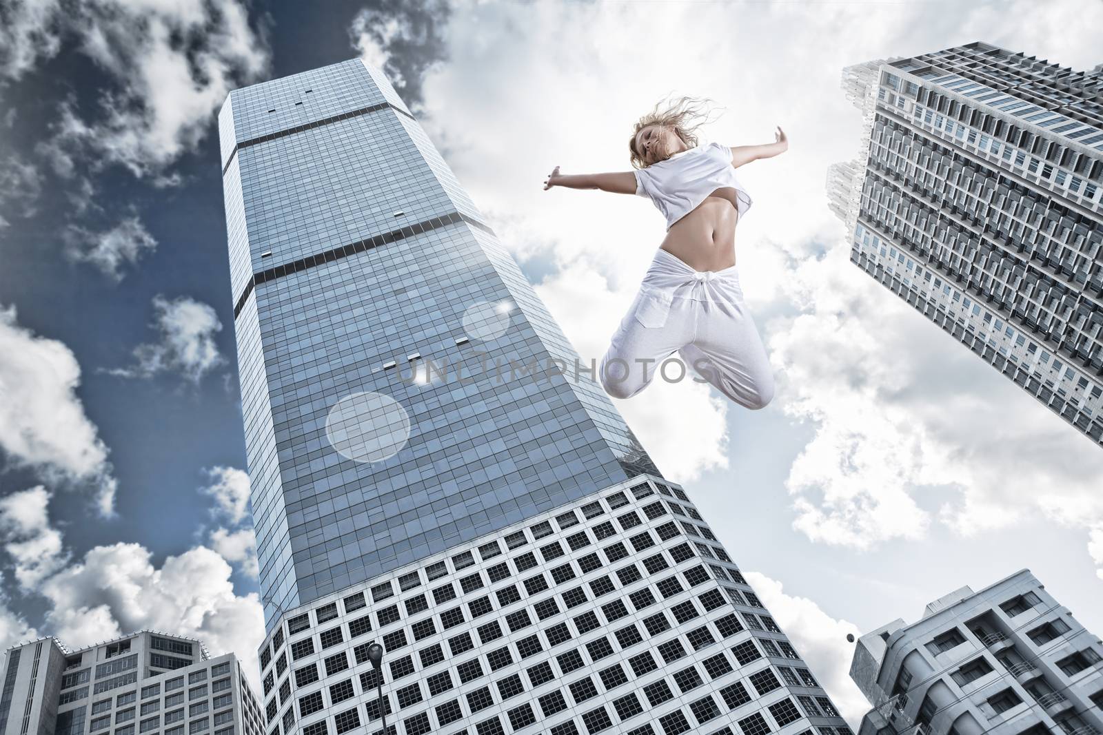 Portrait of young jumping woman on blue sky background