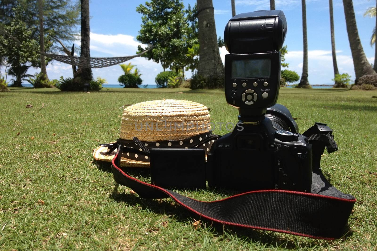 Summer traveling with camera and straw hat on vacation.