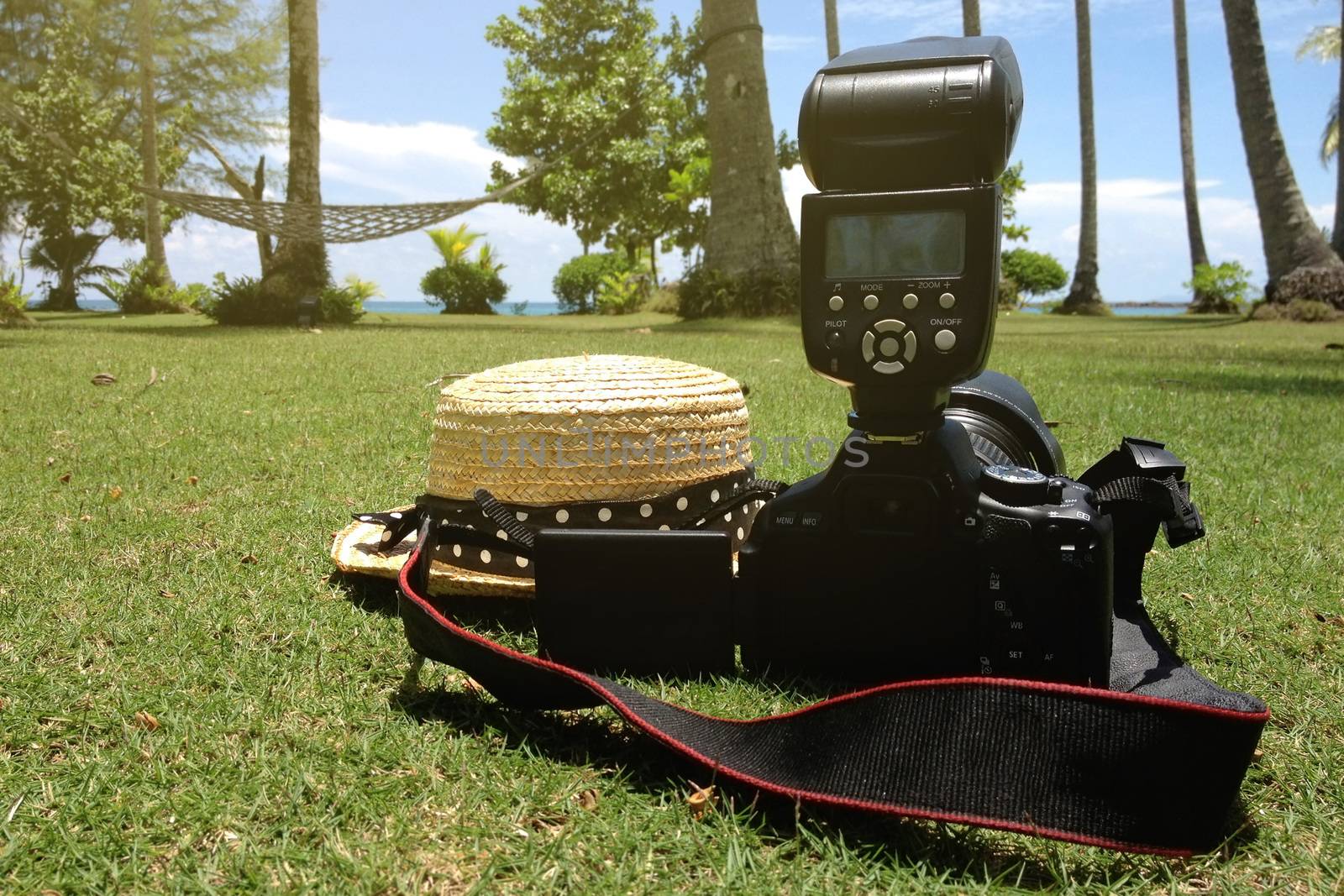 Summer traveling with camera and straw hat on sunny day