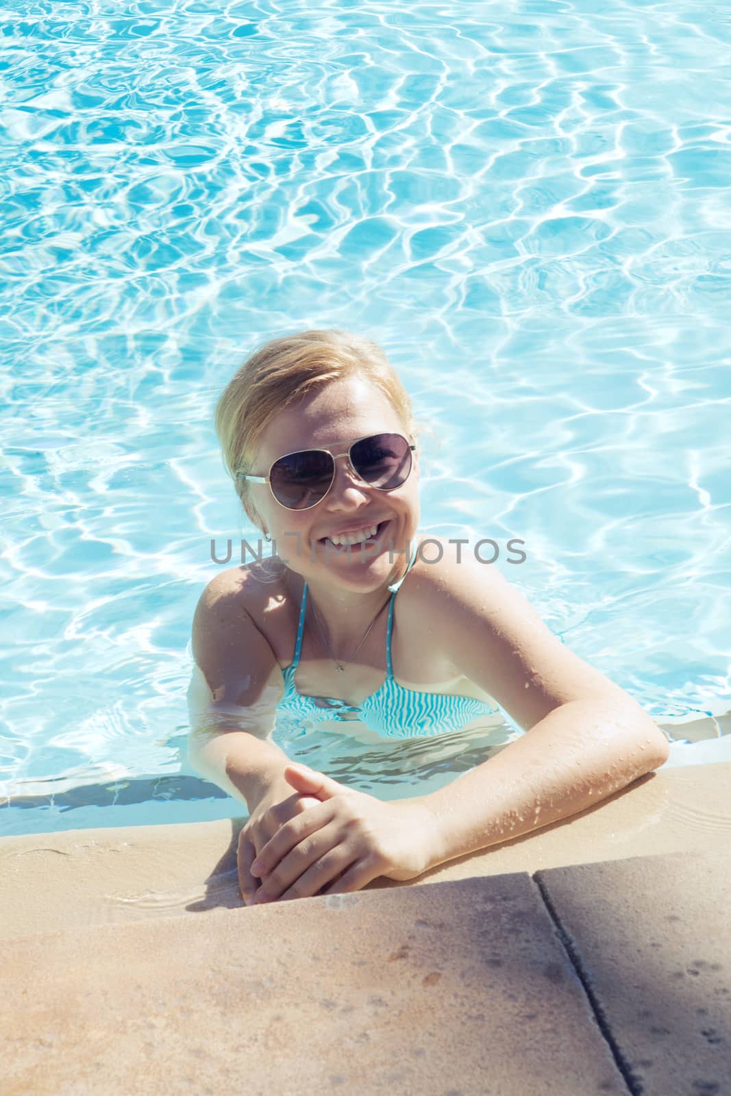 Portrait of young attractive woman having good time swimming pool