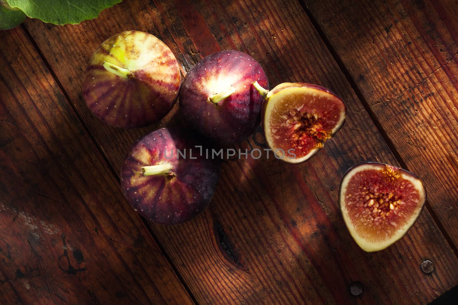 close up view of fresh figs and  leaf on color back