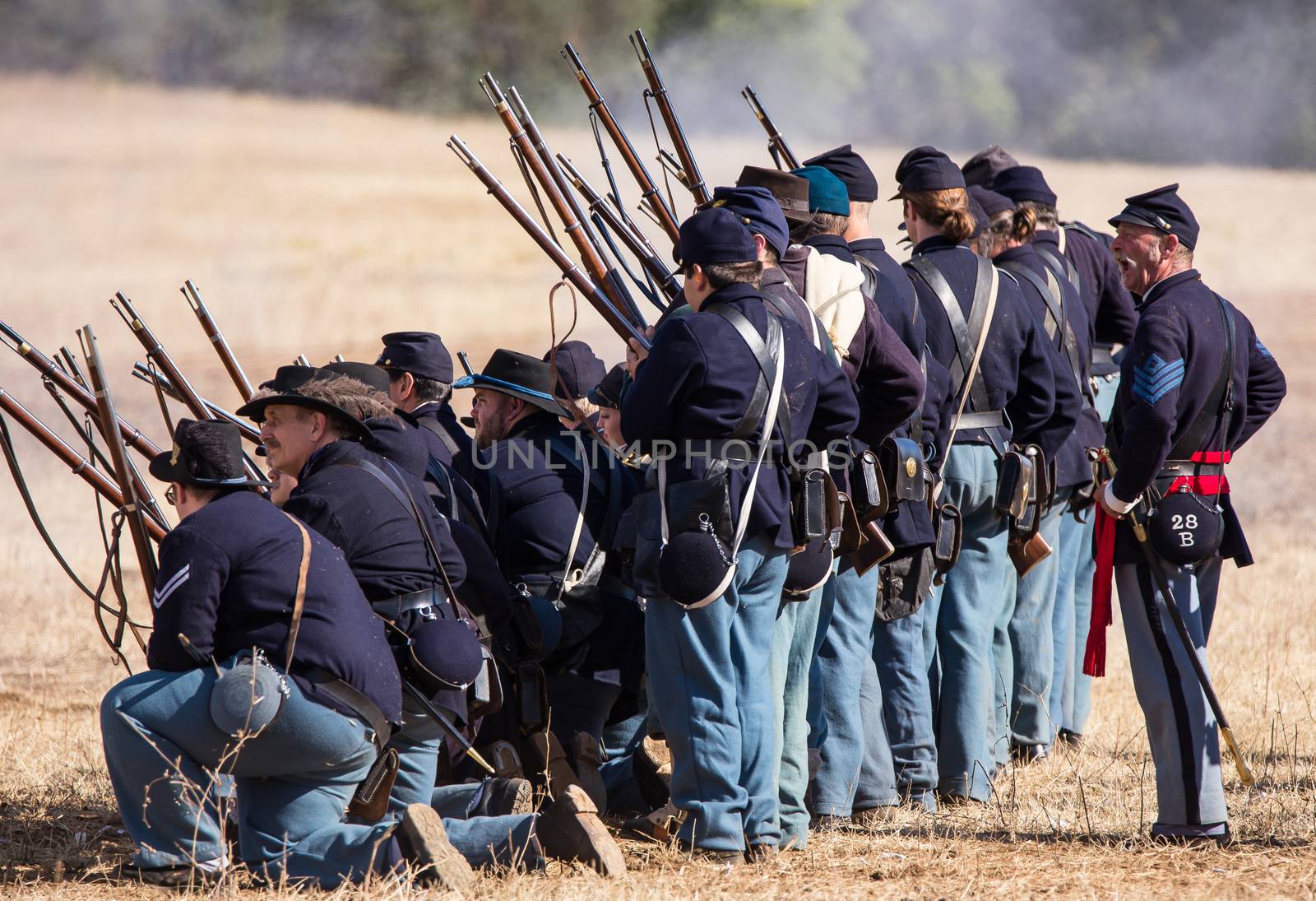 A line of American Civil War infantry from the Northern States fire in line at the Confederate troops across the field at Hawes Farm in northern California.nPhoto taken on: October 03rd, 2015.