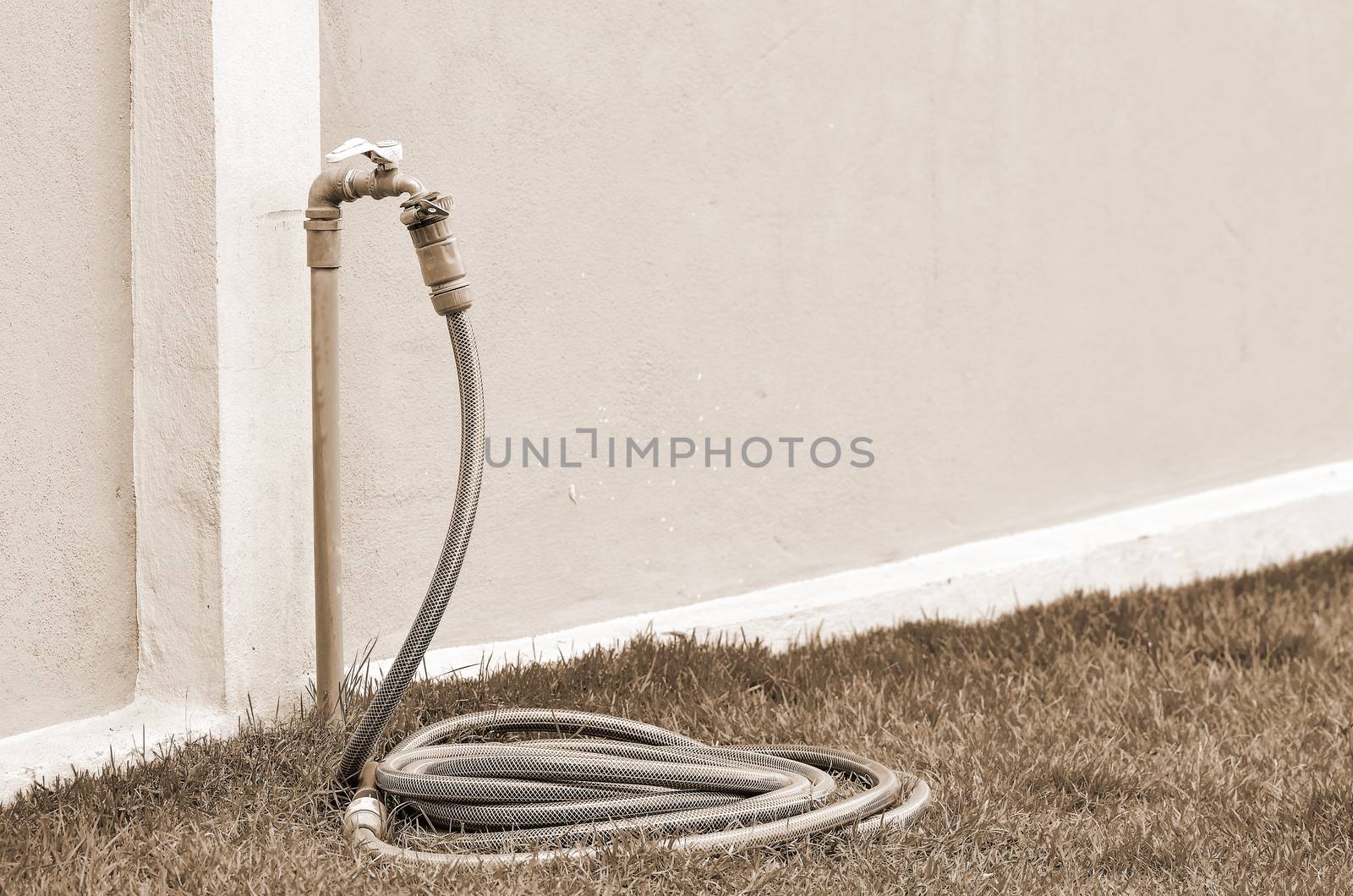 Reel of hose pipe and spraying head in sepia tone