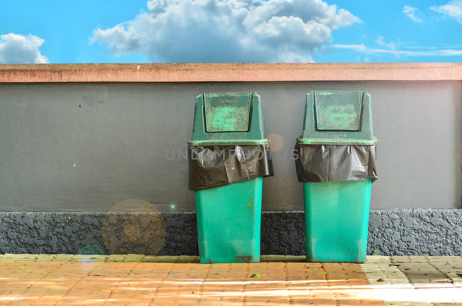 Green trashcan for keeping garbage on blue  sky