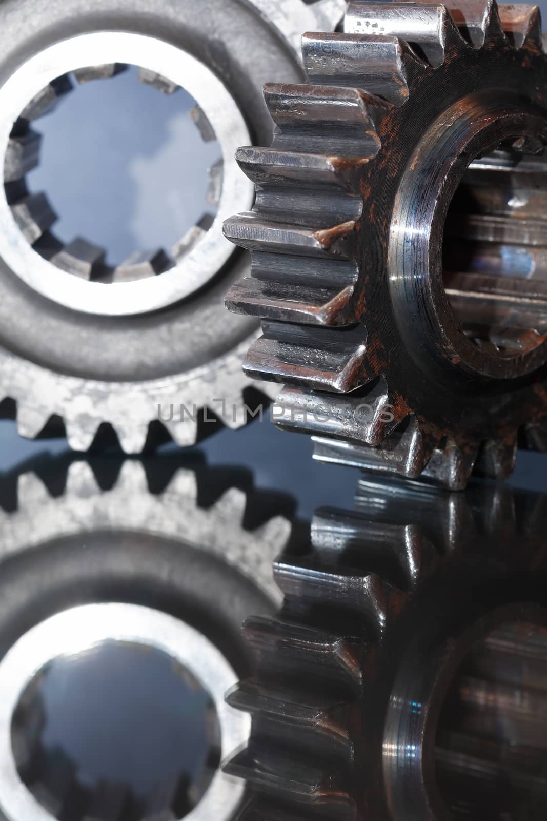 Industrial concept. Two old gears on glass surface with reflection