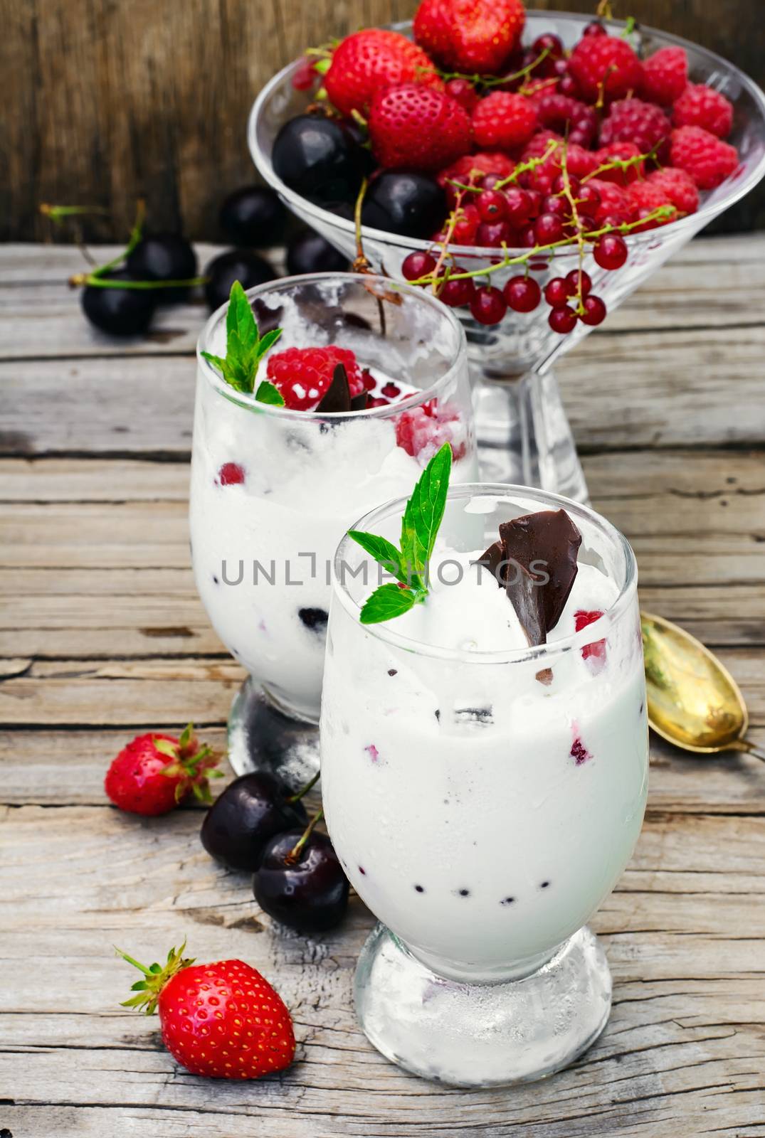 Dairy ice cream with strawberries,currants and raspberries in the glass