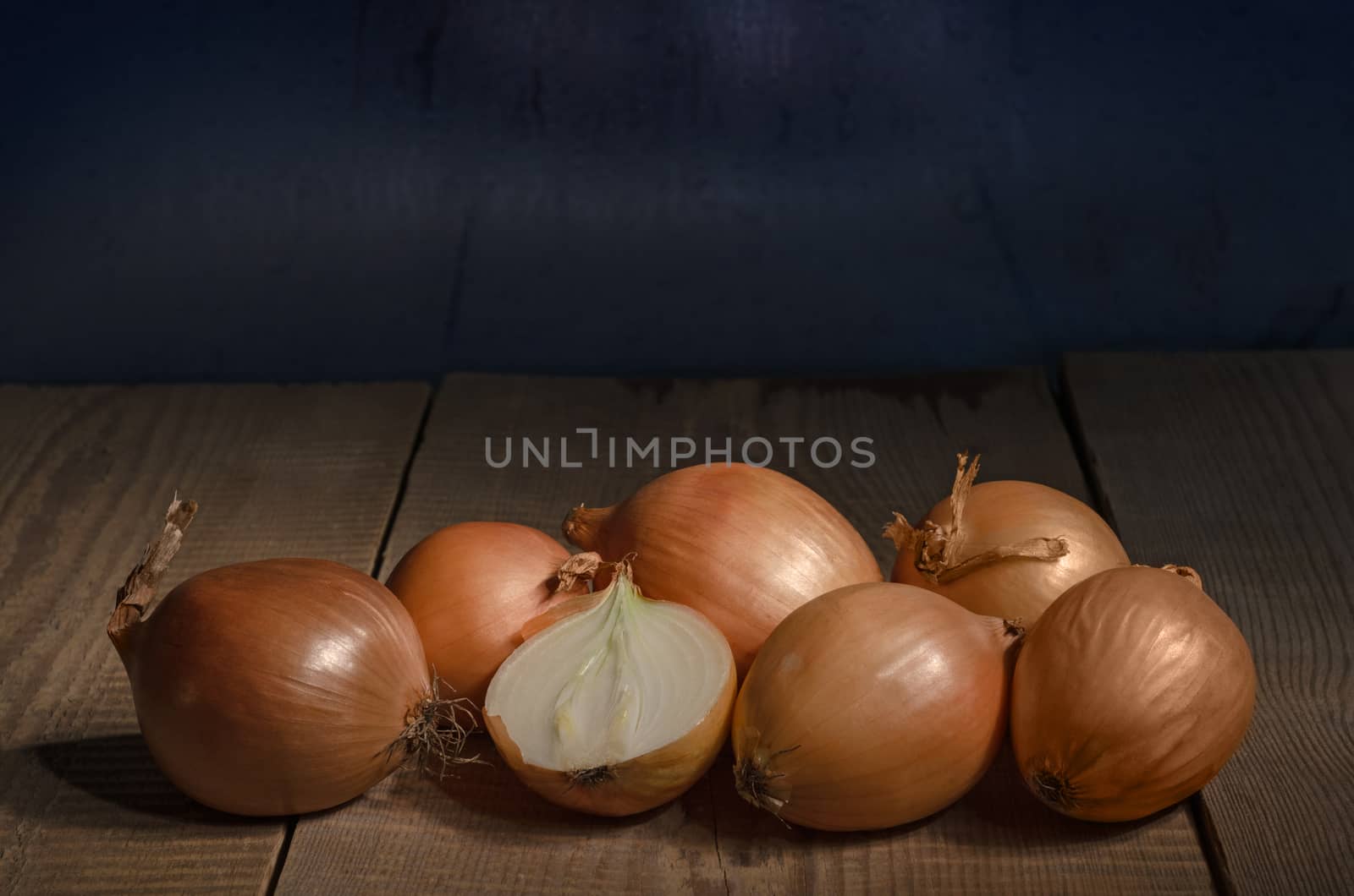 Raw whole onions on the old boards. Place for text.
