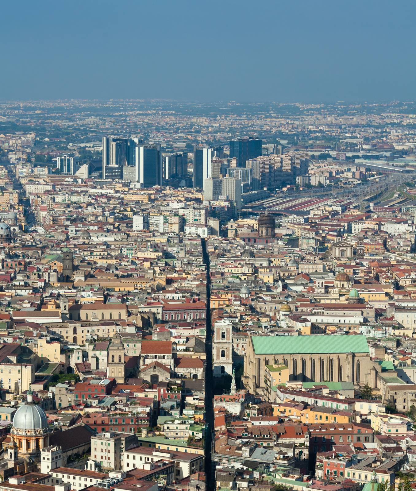View of Spaccanapoli street splitting city center; business district Centro Direzionale skyscrapers are in the background