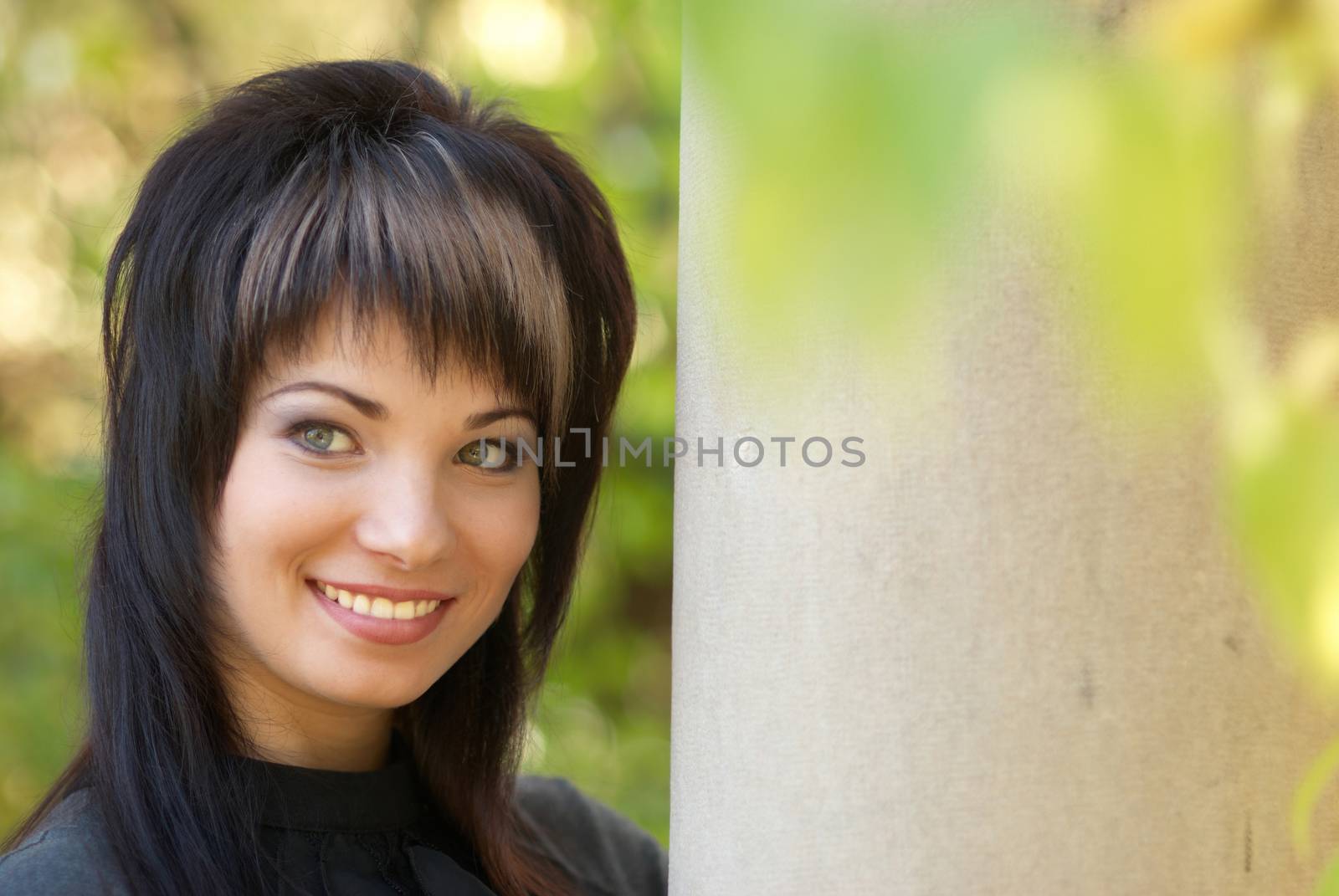 Beautiful girl's portrait near the column with soft background