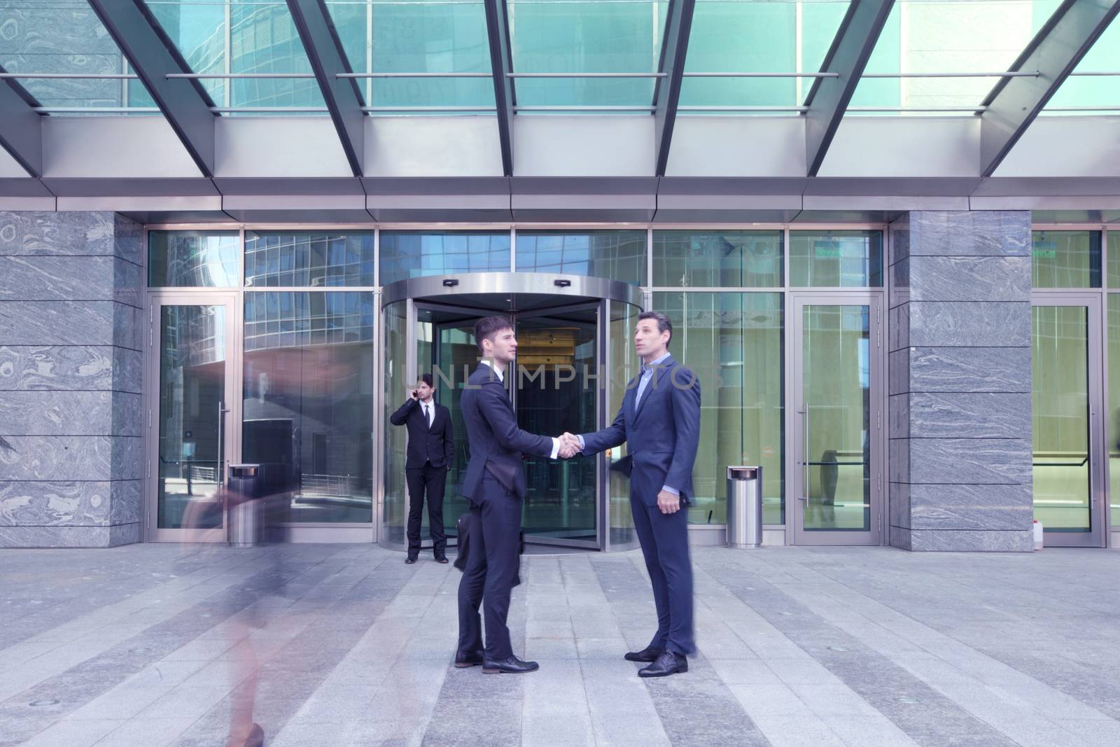 Business people shaking hands, finishing up a meeting outside office