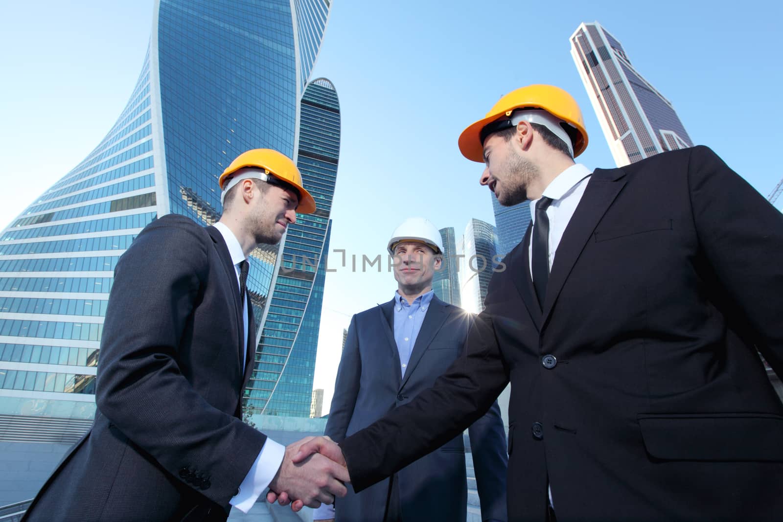 Investor and contractor shaking hands, view from below