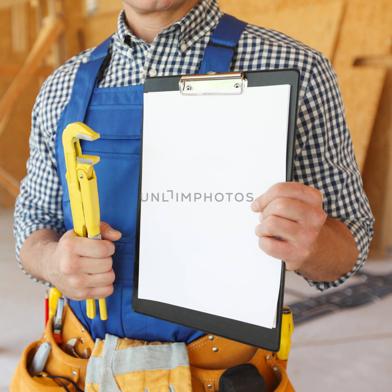 Close-up view of workman with wrench and contract