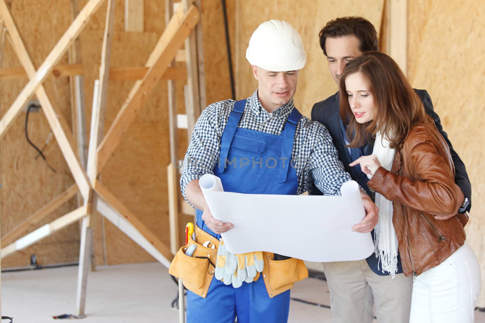 Foreman shows house design plans to a young couple