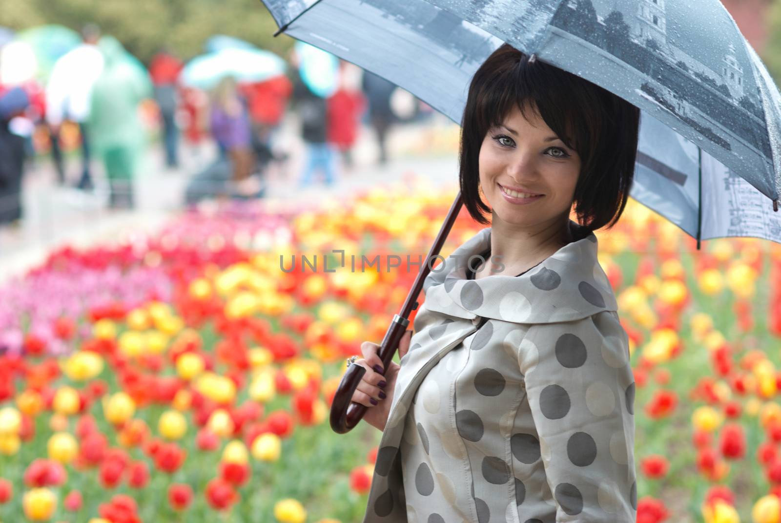 Pretty girl with umbrella in the garden