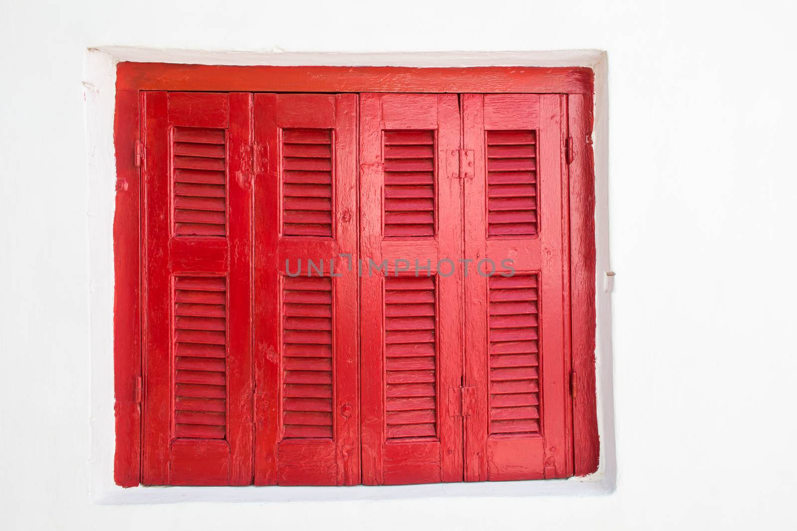 Contrast of the closed red shutter and white painted facade of the house. Plaka, Athens, Greece.