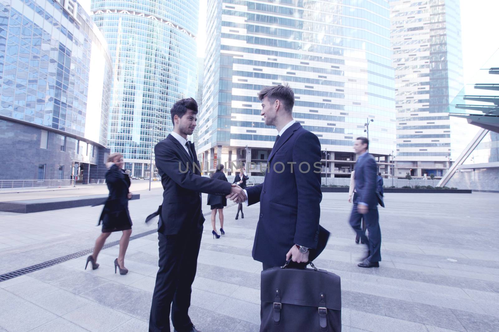 Business people shaking hands, finishing up a meeting outside office