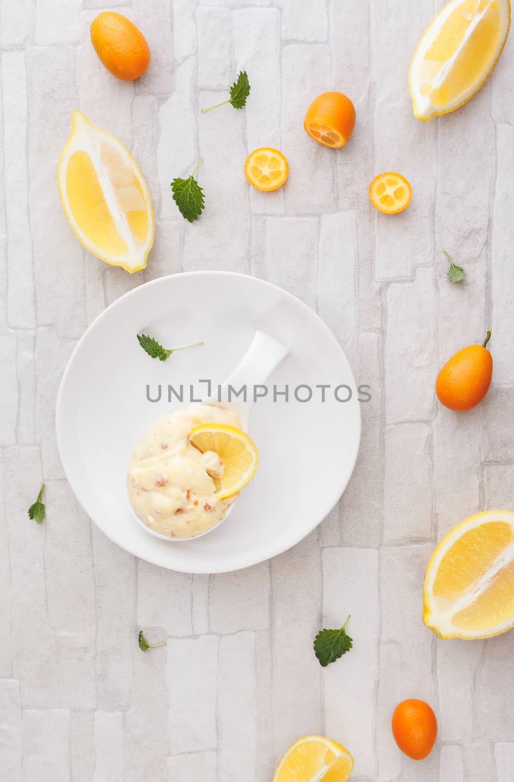 Homemade lemon almond mousse with candied kumquats peel. Top view, blank space, rustic background