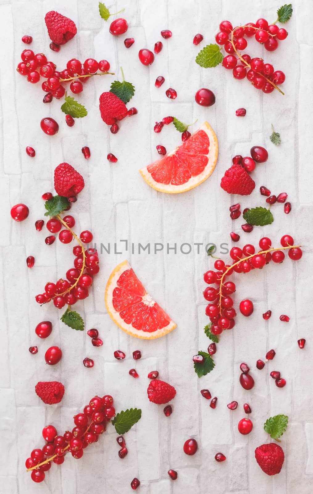 Collection of fresh whole and sliced red fruits on white rustic background. Still life pattern background. Overhead view