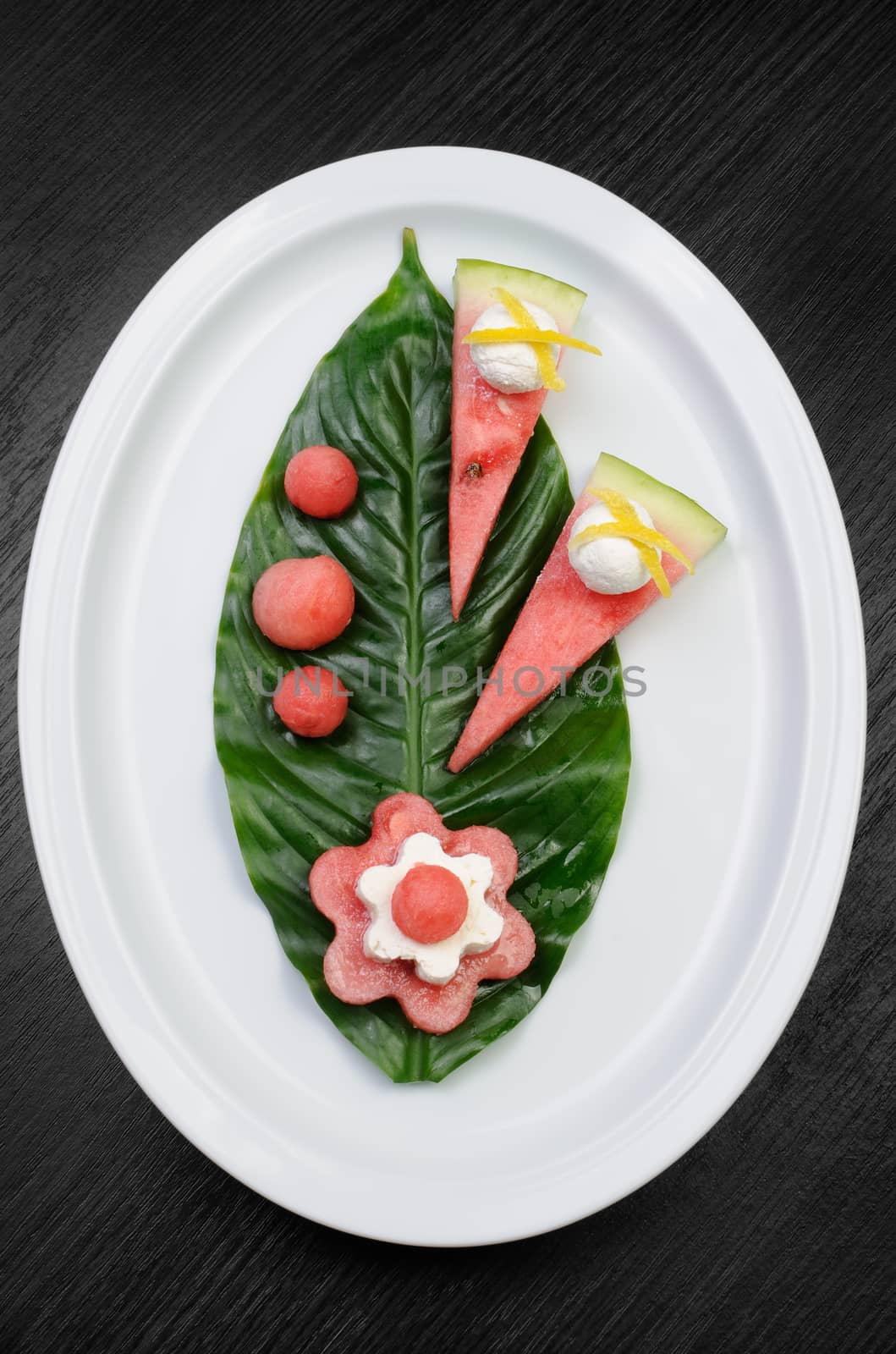 Decorative design of watermelon snack with ricotta on a green leaf