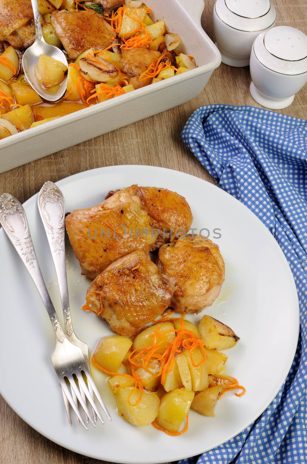 Fried chicken haunch  with boiled potatoes and carrots on a plate