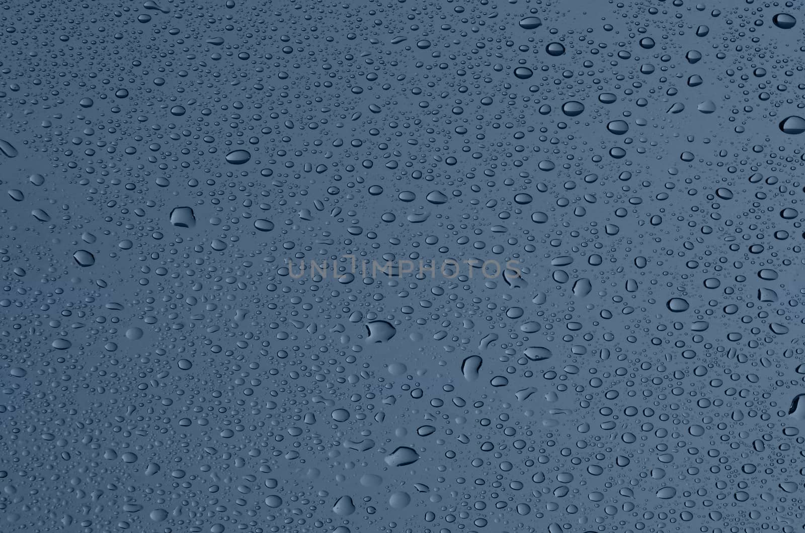 Covered with droplets of water, dark blue-gray glass.