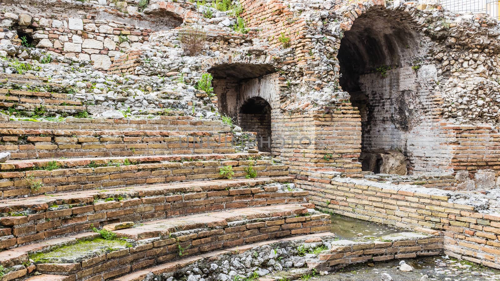 A detail of the ruins of Odeon, the ancient greek theater of taormina, in sicily, landscape cut.