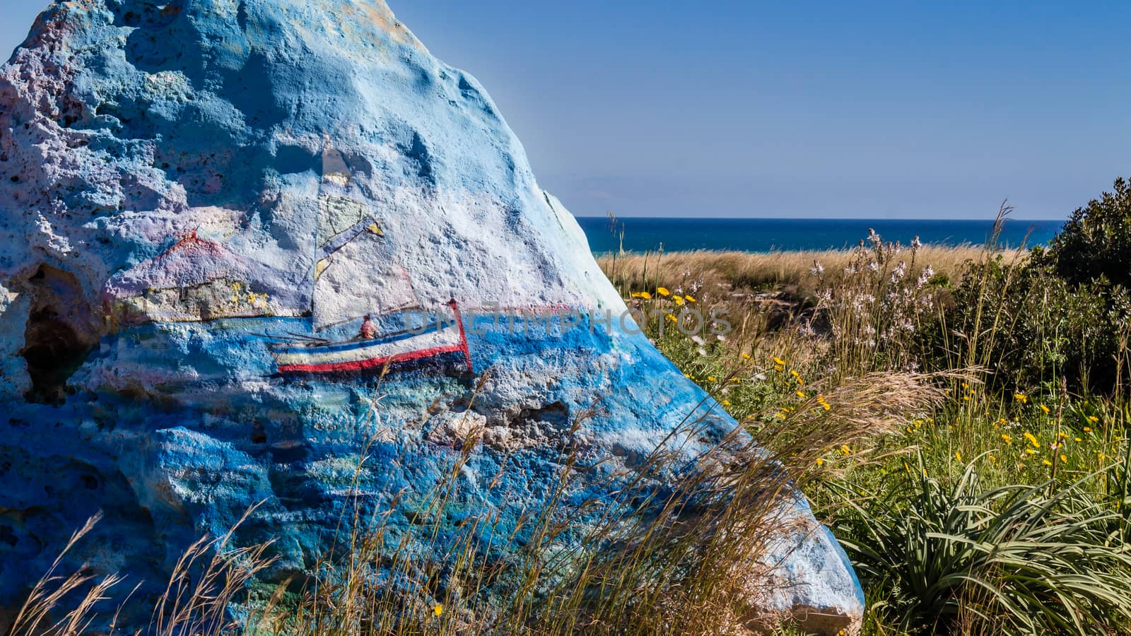 the boat  in the stone sails to blue sea.