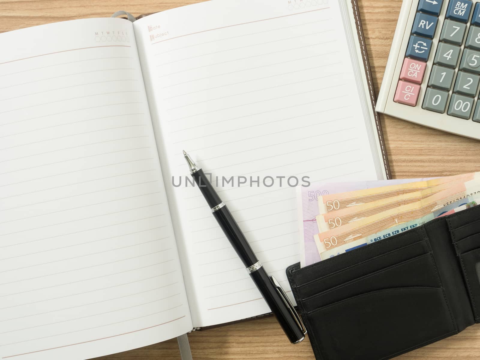 financial Accounting concept. Notebook, pen, banknote and calculator on the desk.