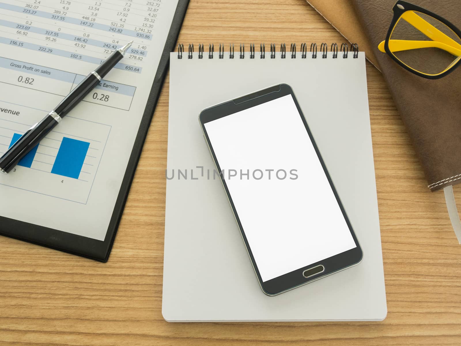 smart phone on work desk with notebook ,report, pen.