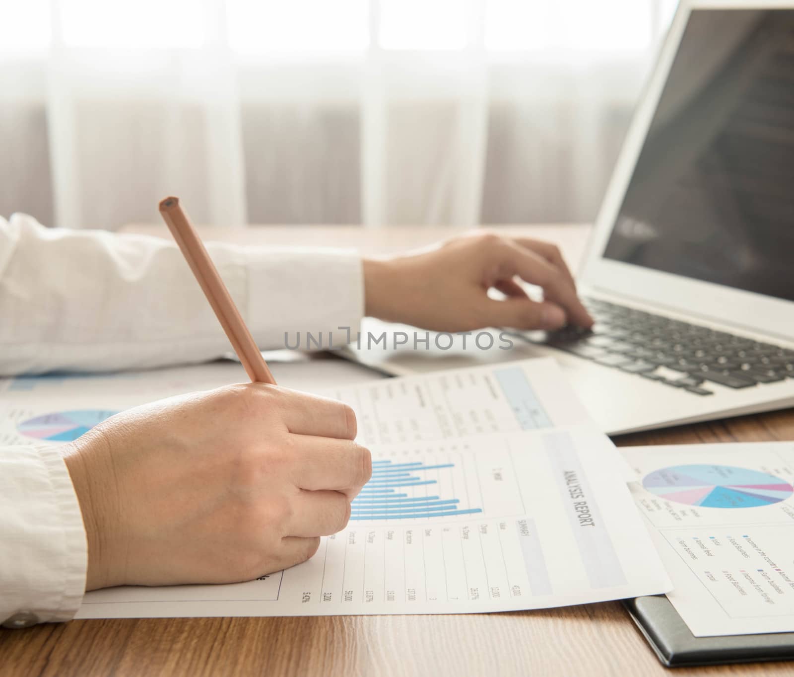 Businessmen are analyzed data from report and a laptop computer.
