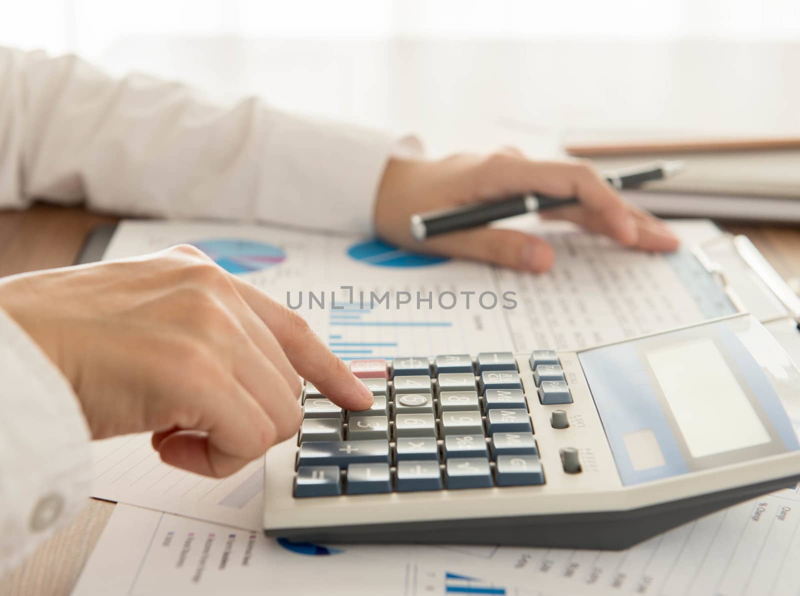 Businessman using a calculator to calculate the numbers