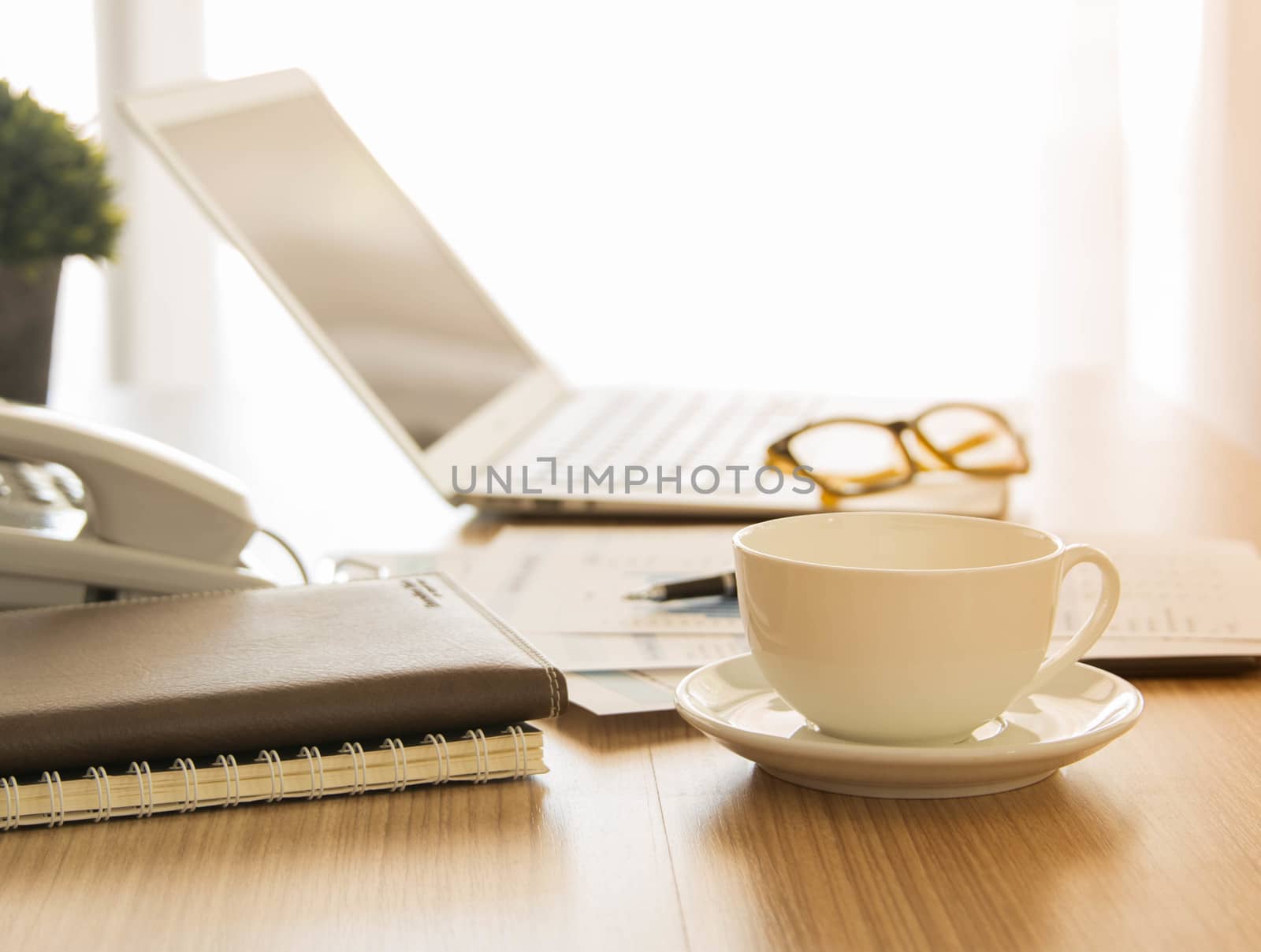 Cup of coffee on the desk of the secretary. warm tone