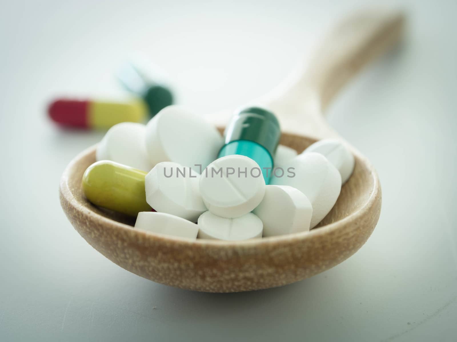 closeup pill in wooden spoon. madical concept