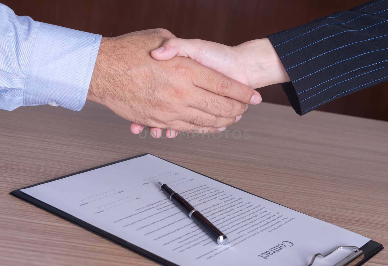 businessman and businesswoman shaking hands to congratulate to be working well.