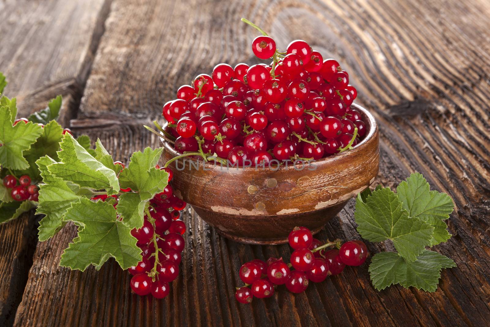 Red currant on wooden background. by eskymaks