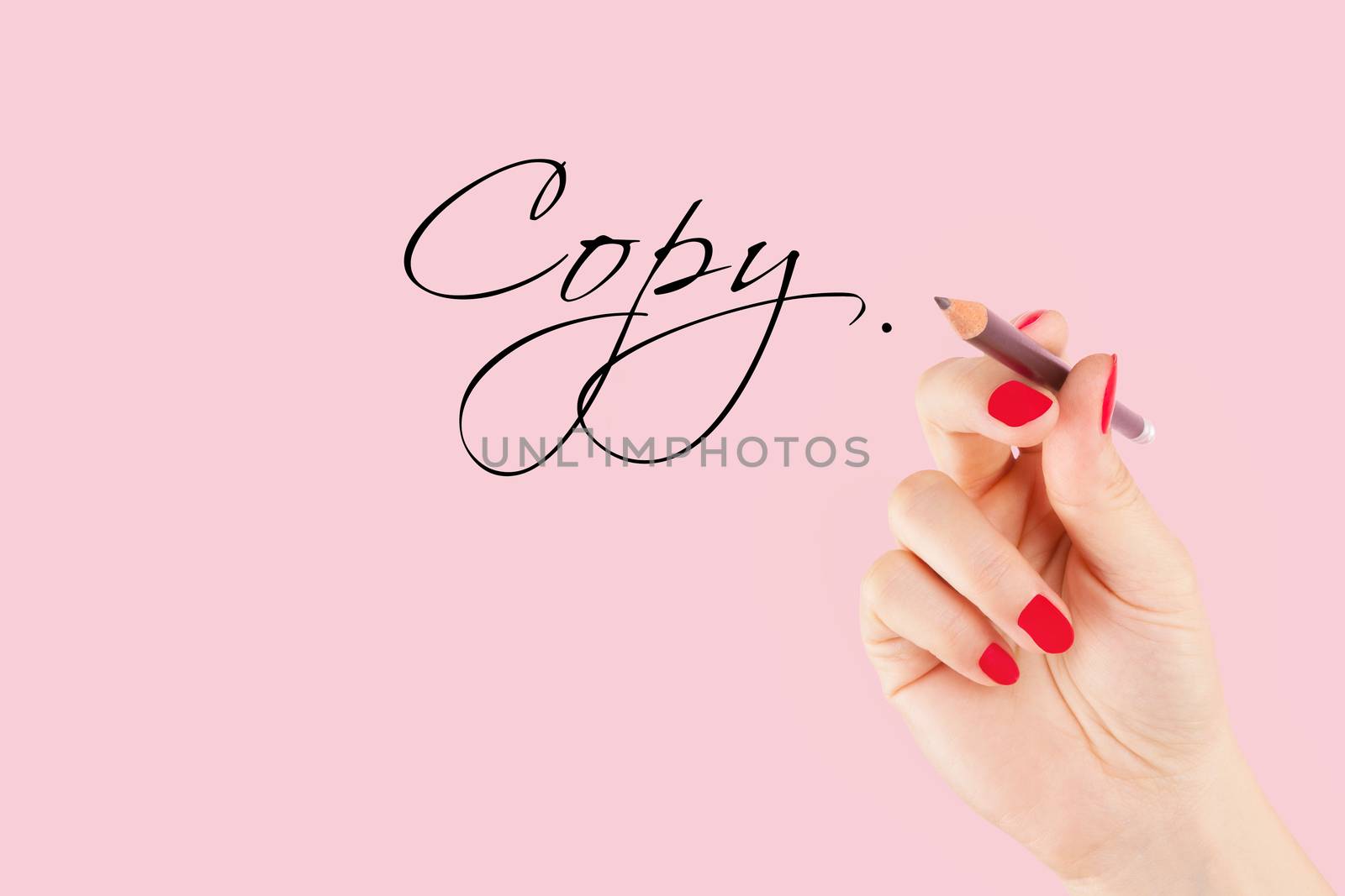 Creative industries. Female hand with pencil writng the word copy in caligraphy. Copy writing.