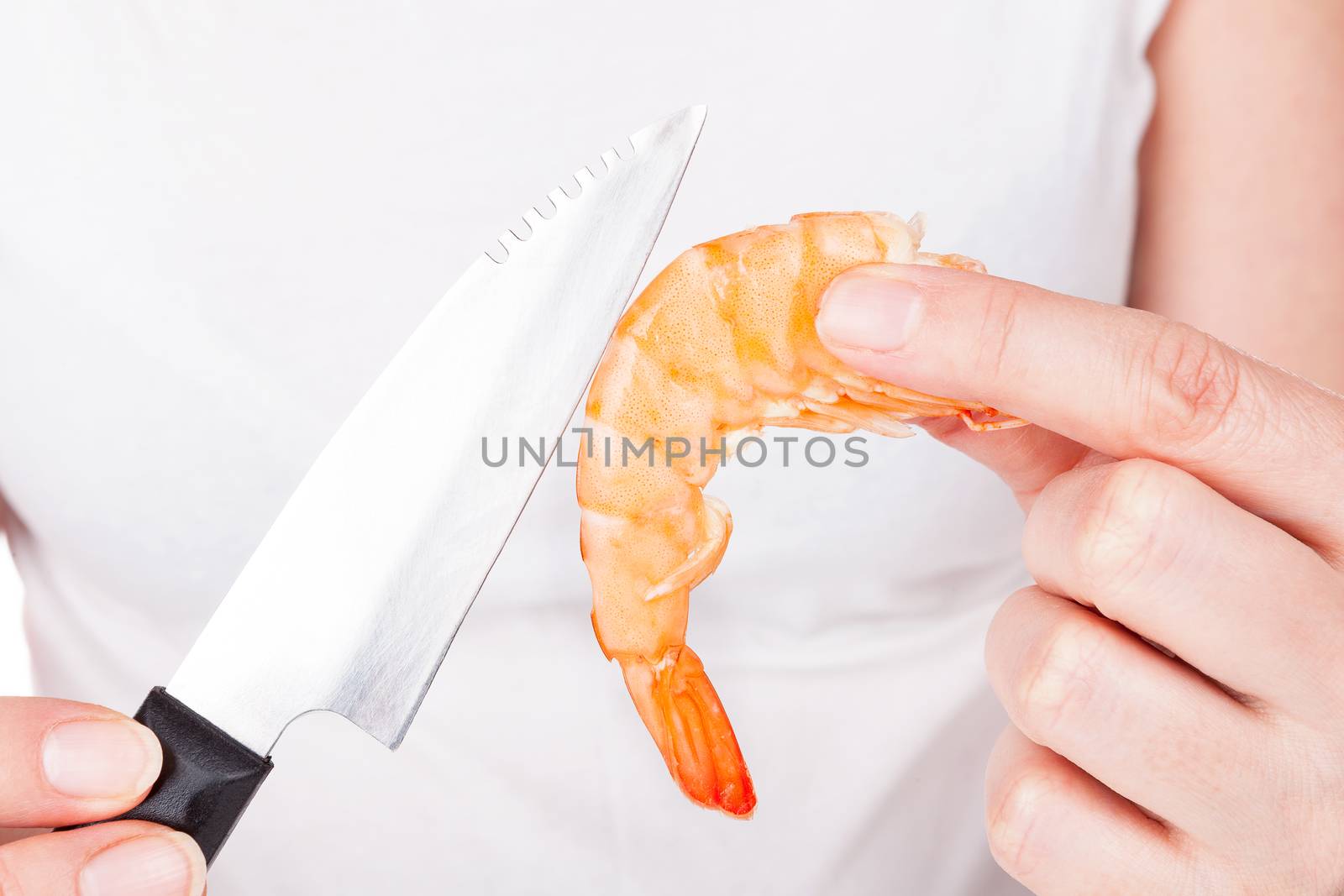 Chef with knife preparing a shrimp. Luxurious seafood cooking, culinary gastronomy.