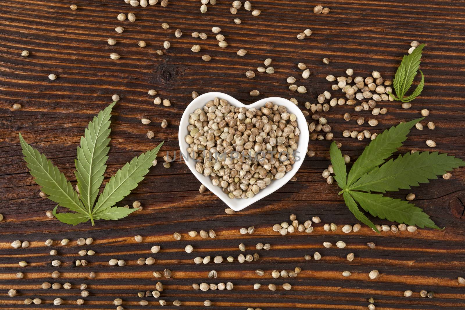 Hemp seeds on wooden background. by eskymaks