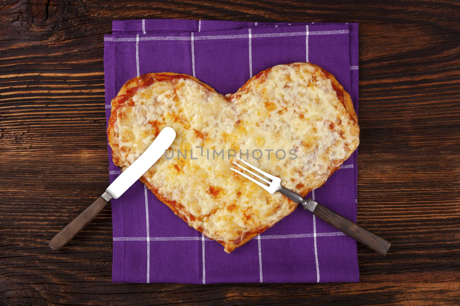 Delicious pizza in heart shape on wooden table, top view. Culinary pizza eating. I love pizza.