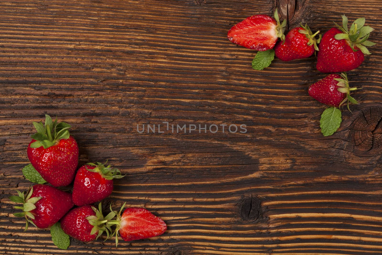 Ripe strawberries on rustic wooden brown table, flat lay. Strawberry background with copyspace. Healthy fruit eating.