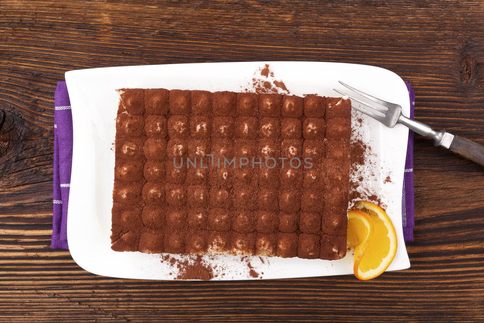 Delicious tiramisu dessert on brown wooden table. Culinary traditional sweet dessert.