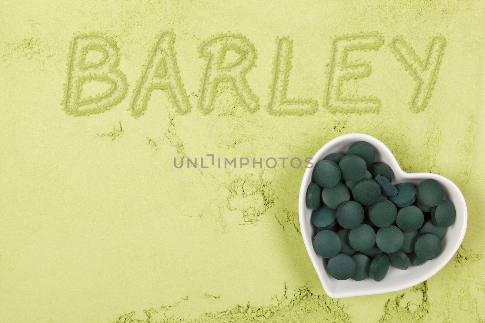 Green food supplement. Word barley written in green ground powder, top view. Healthy lifestyle.