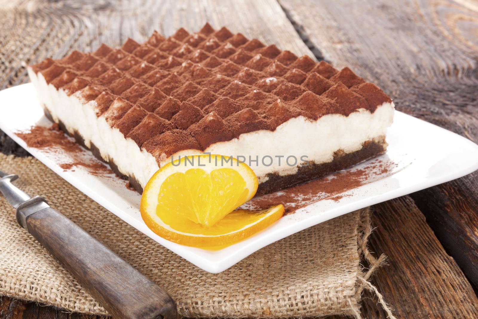 Delicious tiramisu dessert on brown wooden table. Culinary traditional sweet dessert.