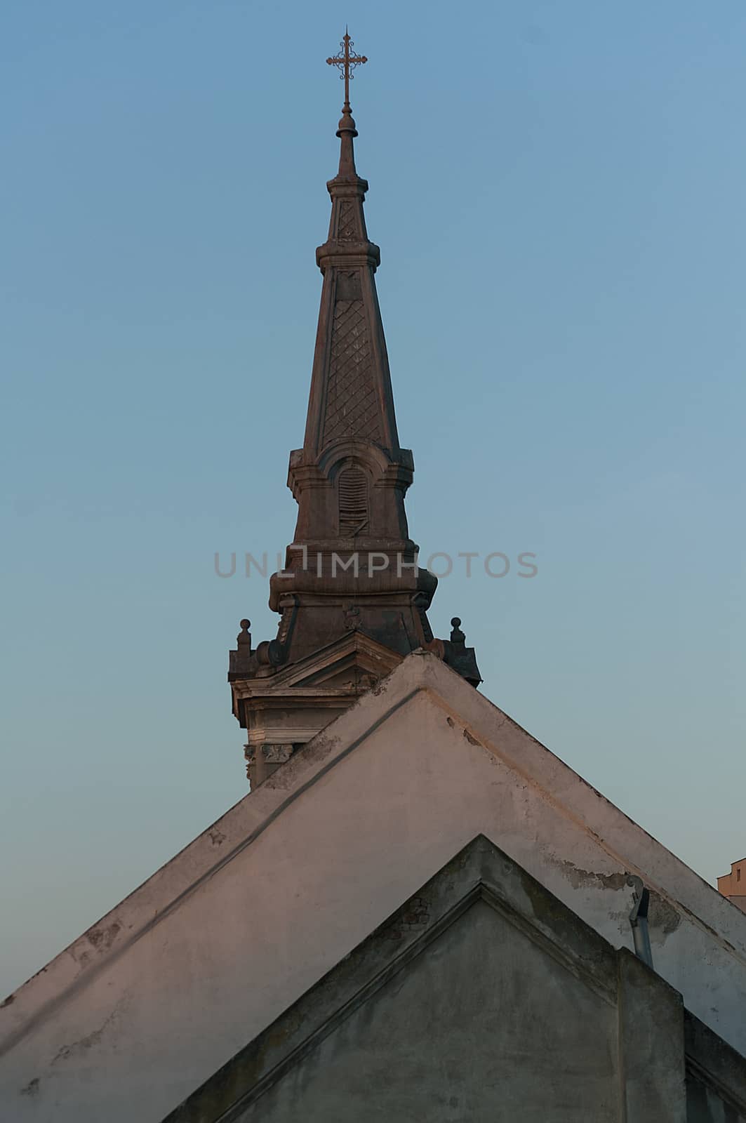 Old roof tops and a steeple of a catholic church. Shapes.