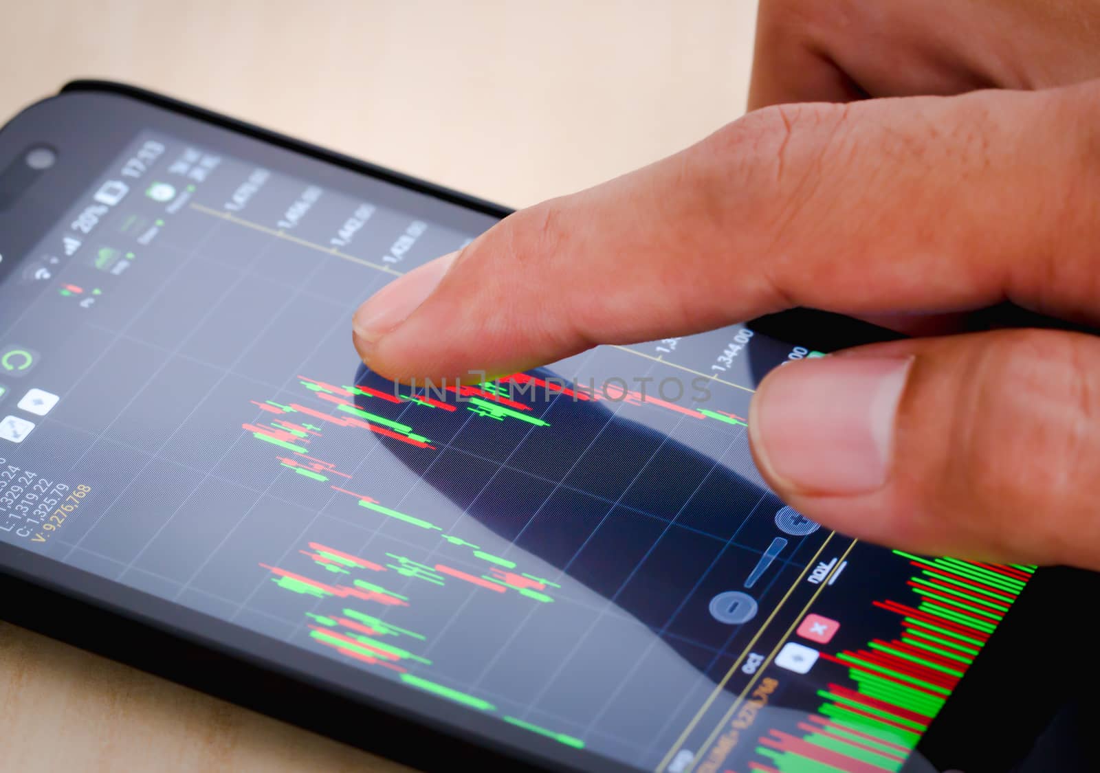 Trading on stock market with smartphone. Closeup photo.