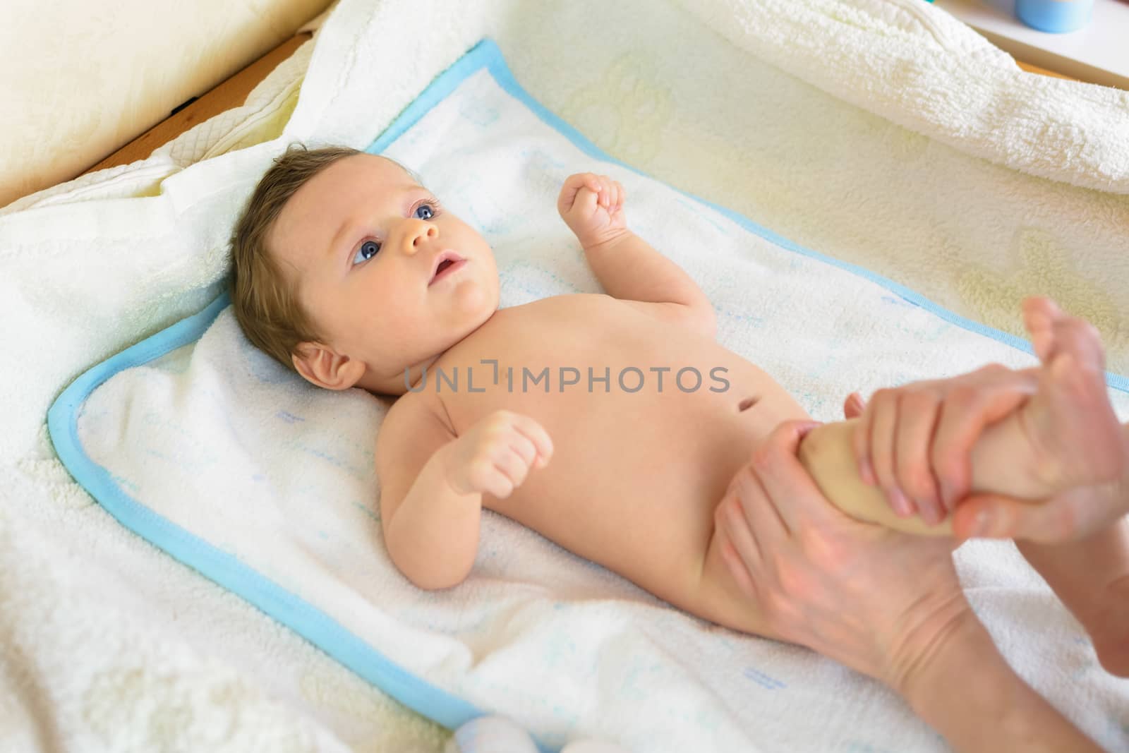 A Infant lying on a towel view mom while making massage