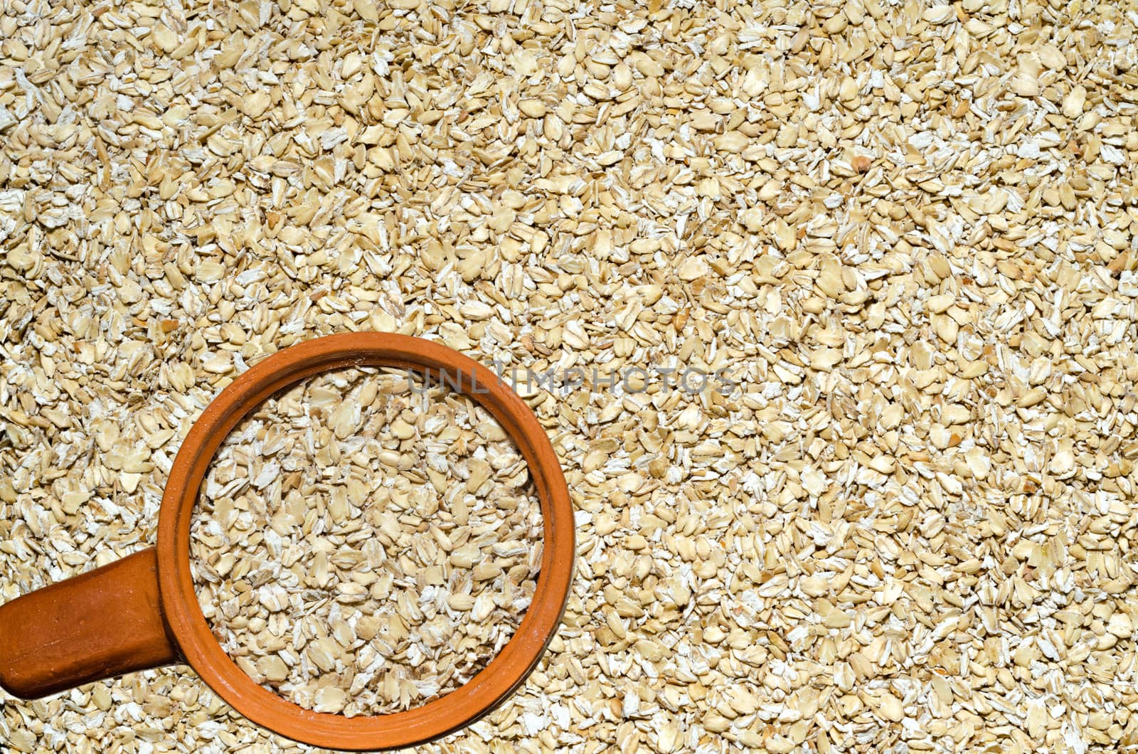 Background texture of uncooked grain cereals Herculean, lying on the table and a ceramic Cup