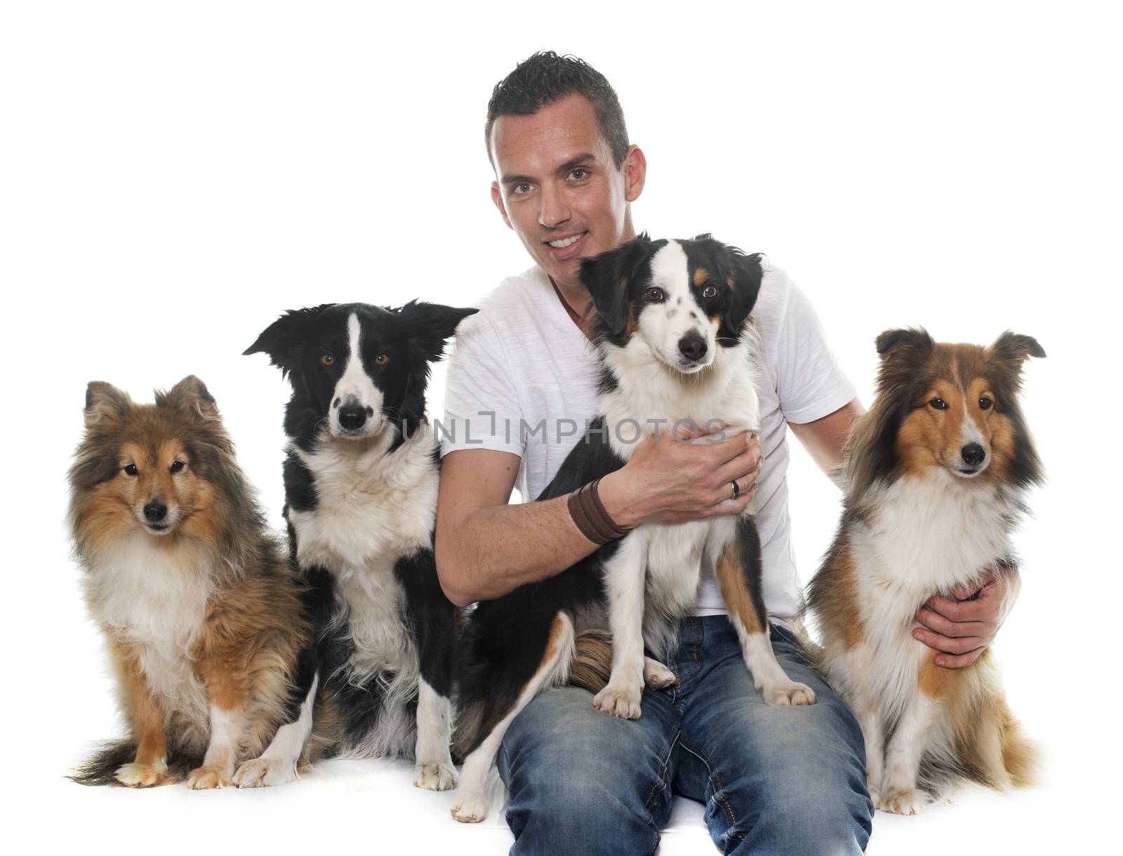four beautiful dogs and man in front of white background