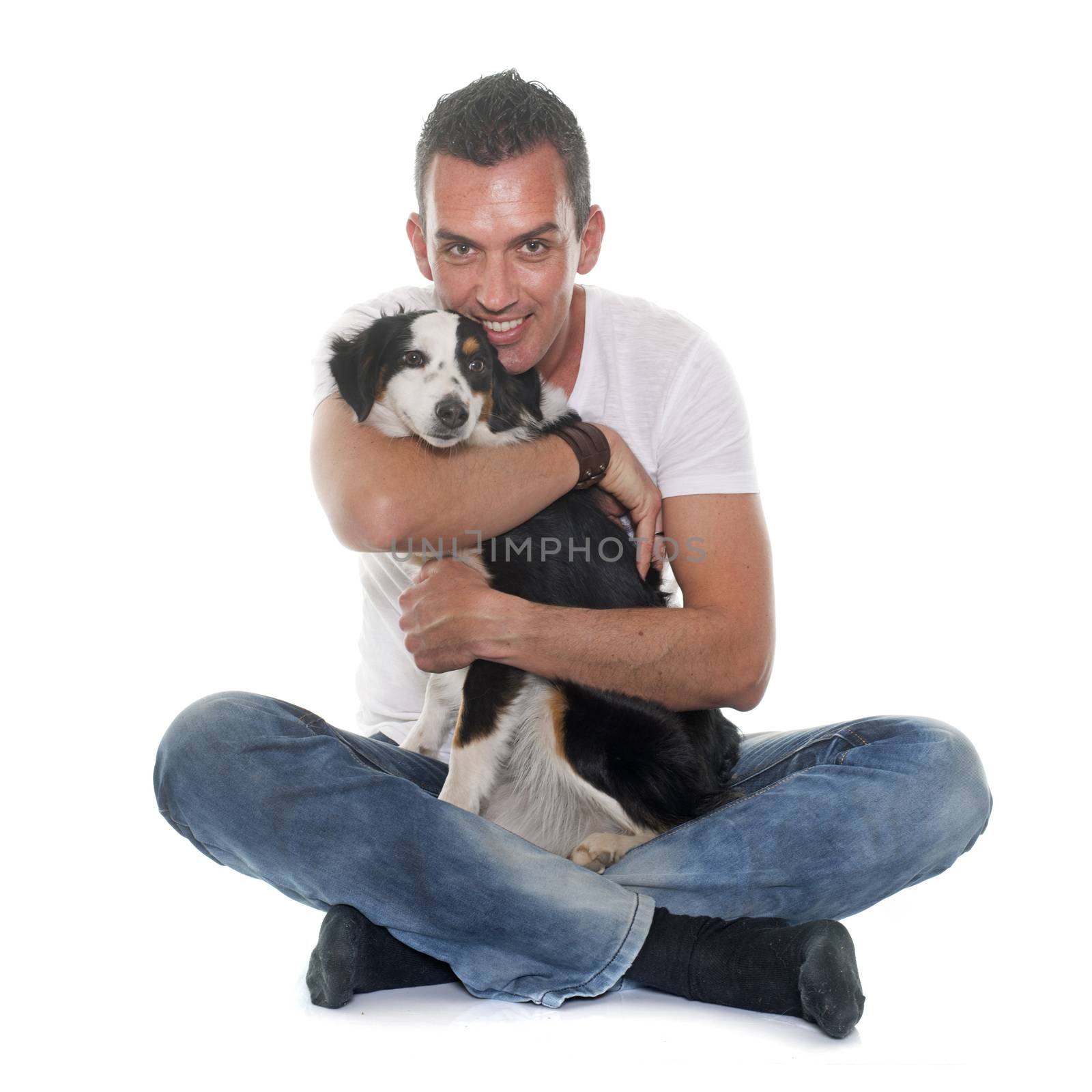 man and miniature australian shepherd in front of white background